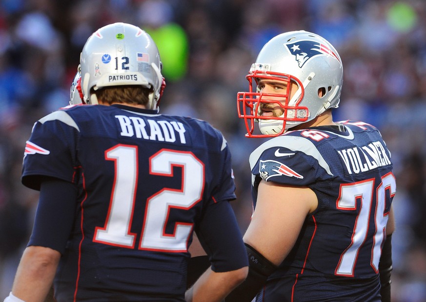 epa04501507 New England Patriots tackle Sebastian Vollmer of Germany (R) talks with New England Patriots quarterback Tom Brady (L) before a play during the first half of the NFL American football game ...