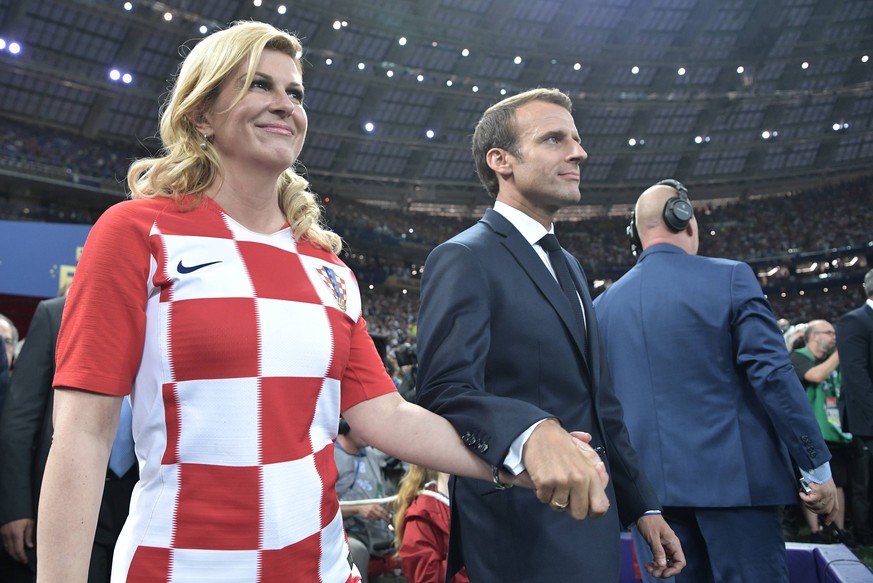 MOSCOW, RUSSIA - JULY 15, 2018: Croatia s President Kolinda Grabar-Kitarovic (L), and France s President Emmanuel Macron (C) at the official award ceremony after the final match of FIFA World Cup WM W ...