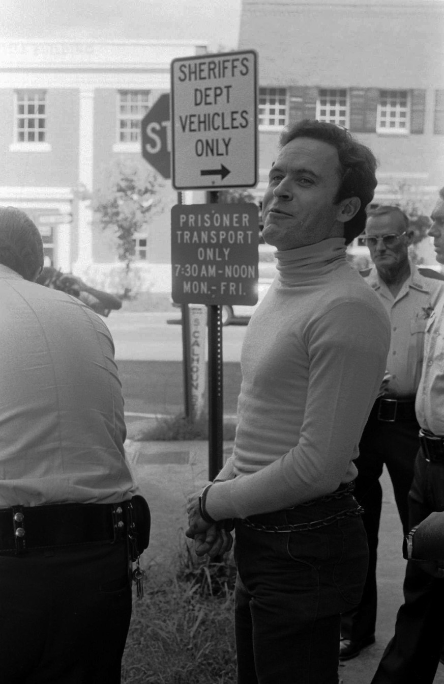 Theodore Bundy calls out to a reporter as he waits to be transported to Leon County Jail in Tallahassee, Fla., Aug. 7, 1978. (AP Photo/Mark Foley) |