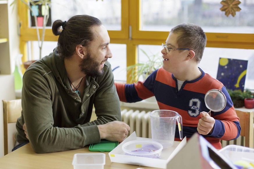 Der Bundesfreiwilligendienstleistende Dorian Schnabel betreut in der Marianne-Cohn-Schule, einem sonderpaedagogischen Foerderzentrum, ein Kind. Berlin, 18.12.2013. Berlin Deutschland PUBLICATIONxINxGE ...