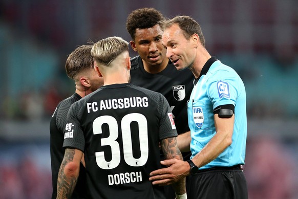 Bastian Dankert im Gespräch mit Spielern vom FC Augsburg. 