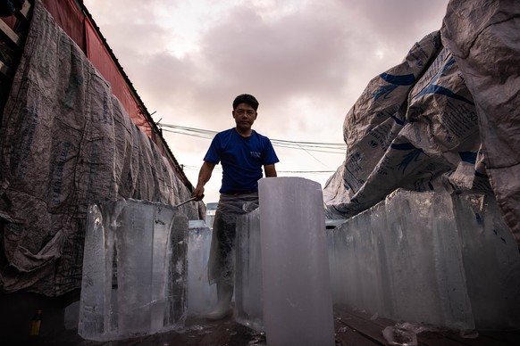 April 28, 2024, Bangkok, Thailand: A man delivers blocks of ice at a market during a period or severe heat warnings from the Thai meteorological department in Bangkok, Thailand, on Sunday, April 28, 2 ...
