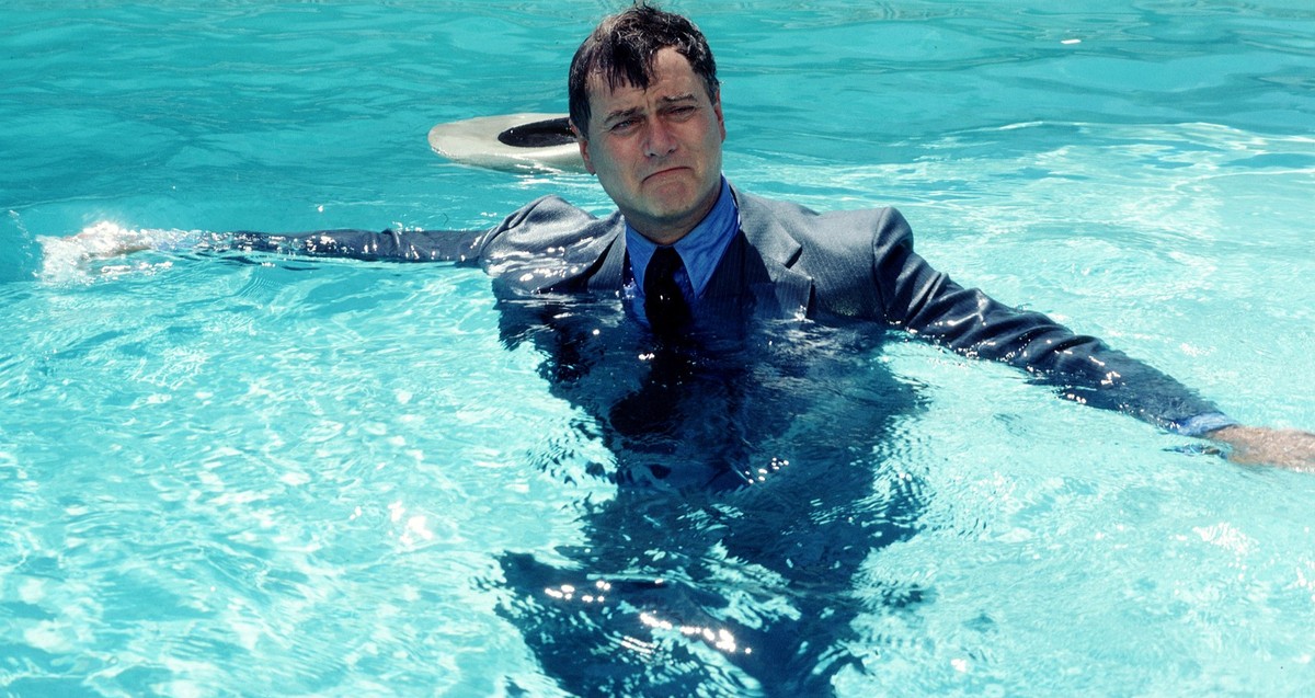 In a scene from the American television series &#039;Dallas,&#039; American actor Larry Hagman (as John Ross &#039;J.R.&#039; Ewing) floats, arms outstretched and fully clothed, in a swimming pool, Au ...