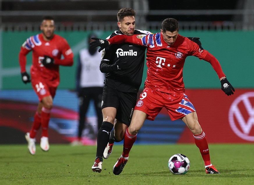 Fußball: DFB-Pokal, Holstein Kiel - Bayern München, 2. Runde im Holstein-Stadion. Kiels Ahmet Arslan und Münchens Robert Lewandowski (r) in Aktion. WICHTIGER HINWEIS: Gemäß den Vorgaben der DFL Deutsc ...