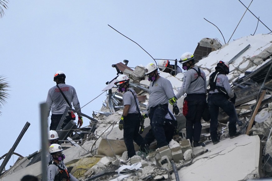 Rescue workers look through the rubble where a wing of a 12-story beachfront condo building collapsed, Thursday, June 24, 2021, in the Surfside area of Miami. (AP Photo/Lynne Sladky)