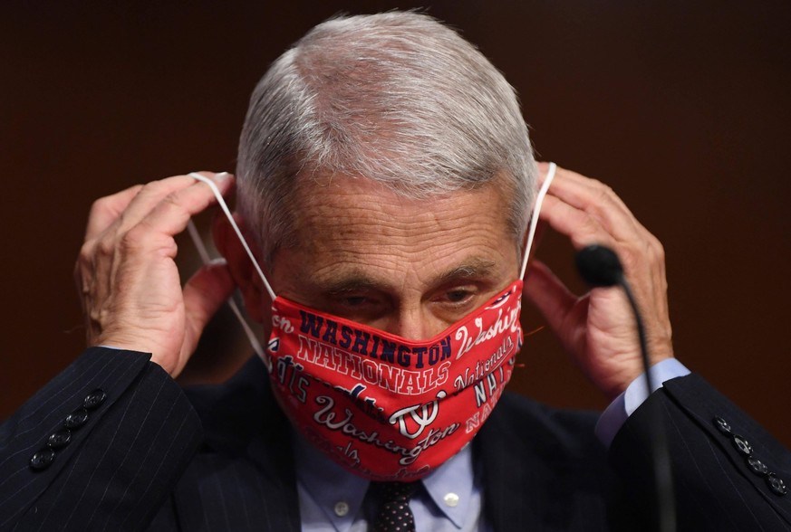 Dr. Anthony Fauci, director of the National Institute for Allergy and Infectious Diseases, lowers his face mask as he prepares to testify before the Senate Health, Education, Labor and Pensions HELP C ...