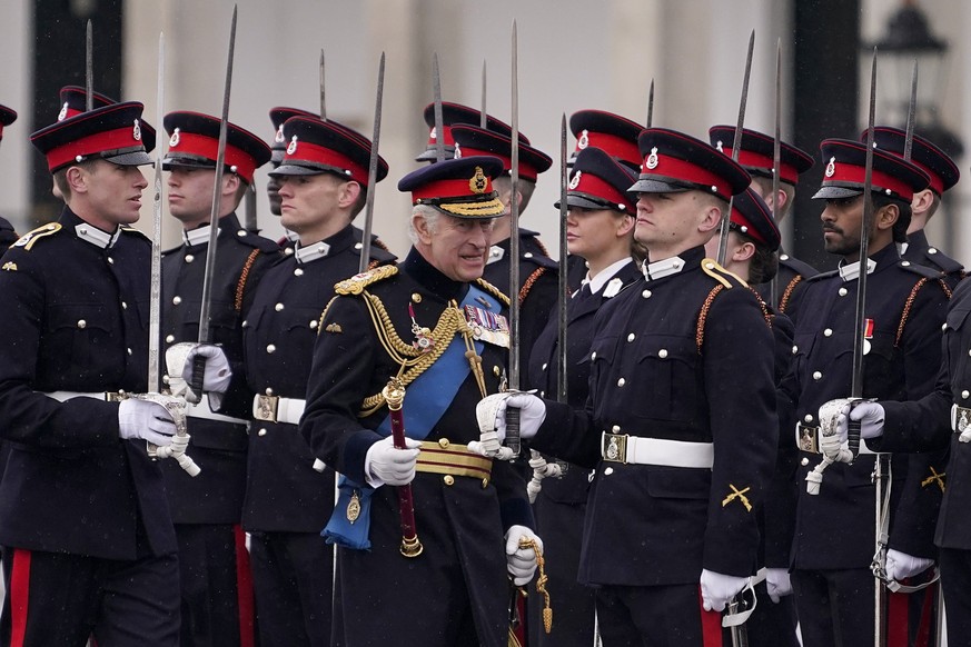 14.04.2023, Großbritannien, Camberley: König Charles III. (M) überreicht den Fähnrichen die neuen Fahnen und das Banner des Souveräns im Rahmen der 200. Sovereign&#039;s Parade der Königlichen Militär ...