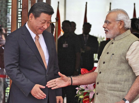 FILE- Indian Prime Minister Narendra Modi welcomes Chinese President Xi Jinping upon the latter&#039;s arrival at a hotel in Ahmadabad, India, Wednesday, Sept. 17, 2014. India is protesting a new Chin ...
