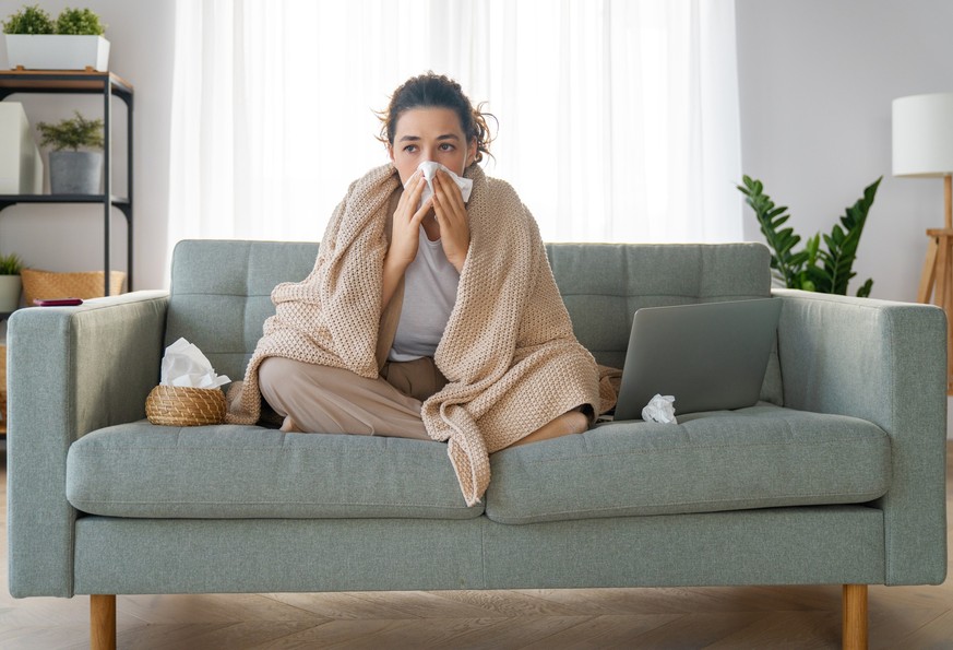 Ill upset girl is holding paper tissue and blowing nose. Virus symptom concept.