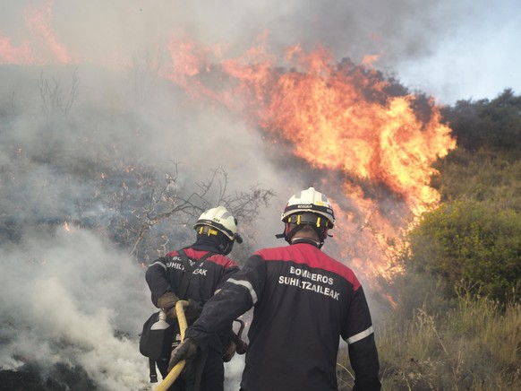 Several firefighters try to put out the fire in Tafalla, June 15, 2022, in Tafalla, Navarra (Spain). The fire affecting in Tafalla an area near the NA-132 road that had already been controlled has bee ...
