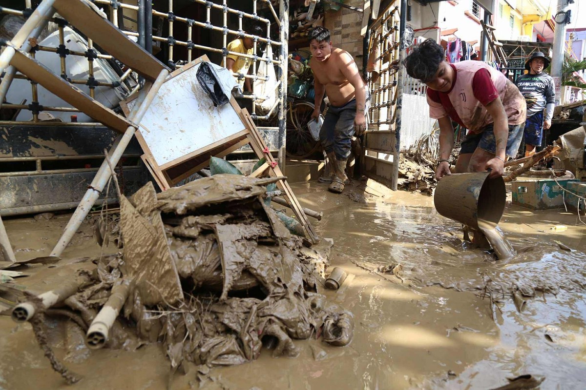 05.11.2025, Philippinen, Talisay: Einwohner räumen vor ihren Häusern auf, nachdem der Taifun Kalmaegi Verwüstungen angerichtet hat. Foto: Jacqueline Hernandez/AP/dpa +++ dpa-Bildfunk +++