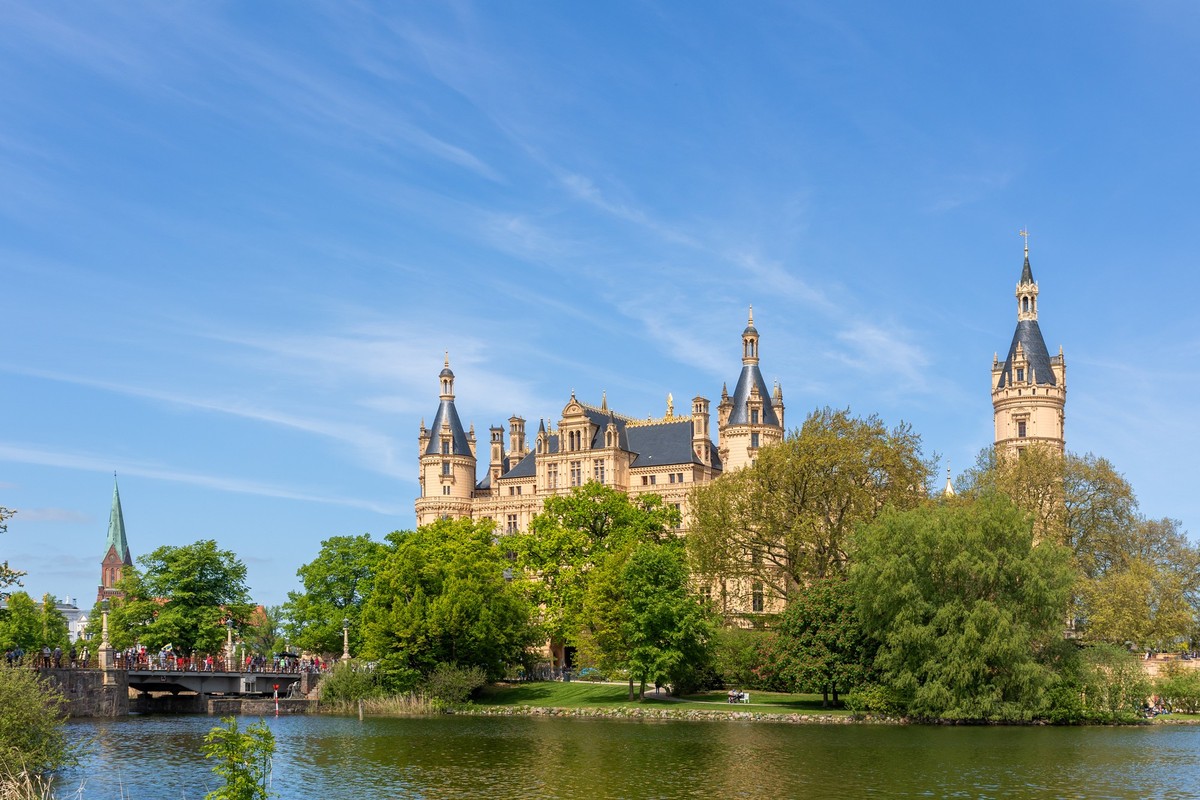 Schwerin Castle on Island in Schwerin Mecklenburg Vorpommern land Germany. Scenic view of historic german Schweriner palace with green garden against bright blue sky in Europe travel destination. Mode ...