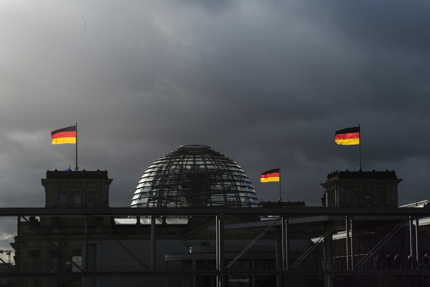 FILE - In this Friday, Nov. 29, 2019 file photo, German national flags catch the sun on top of the German parliament building, the Reichstag building in Berlin, Germany. German voters elect a new parl ...
