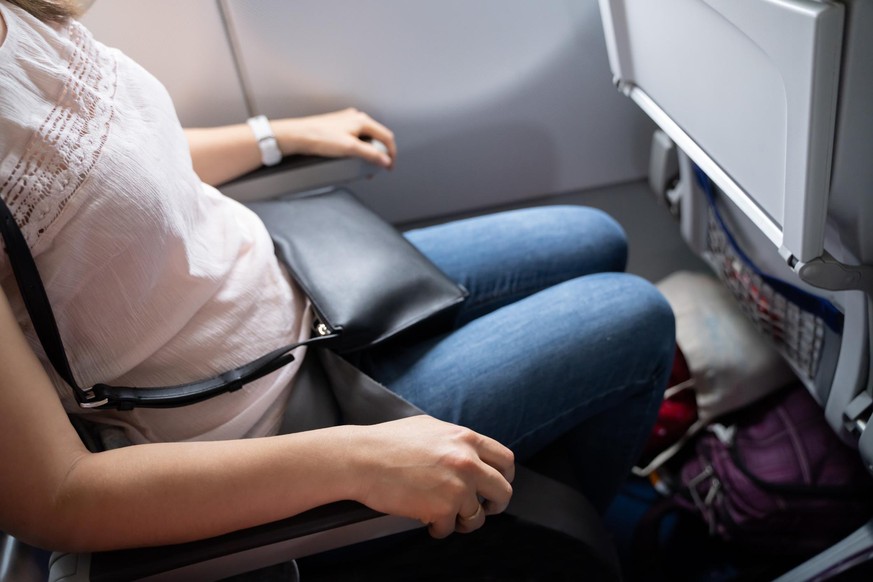 Nervous Woman Holding Armrests Tight In Airplane