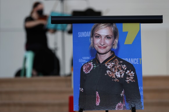 A musician plays a violin behind a photograph of cinematographer Halyna Hutchins during a vigil in her honor in Albuquerque, N.M., Saturday, Oct. 23, 2021. Hutchins was fatally shot on Thursday, Oct.  ...