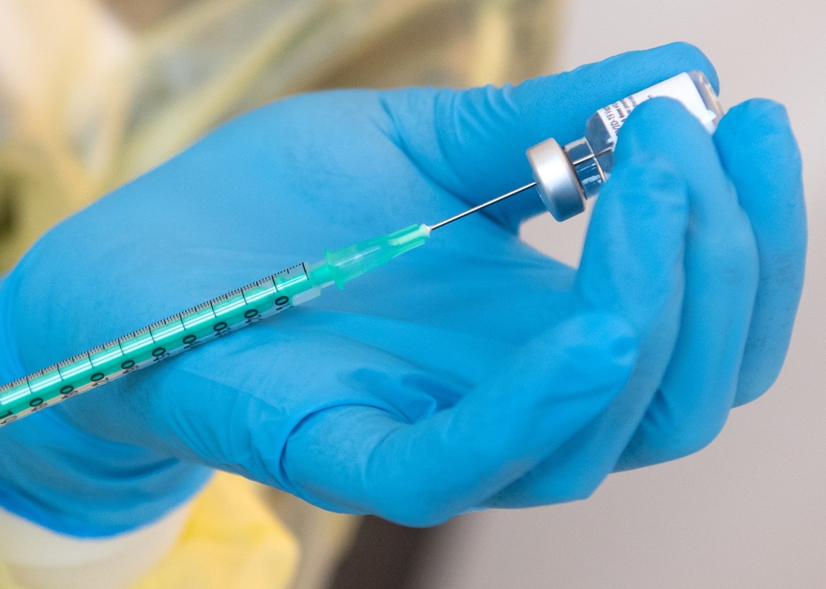 ARCHIV - 10.01.2021, Bayern, Pfaffenhofen a.d.Ilm: Eine Mitarbeiterin vom bayerischen roten Kreuz (BRK) bereitet in einem Impfzentrum einen Impfstoff gegen das Corona-Virus SARS-CoV-2 f