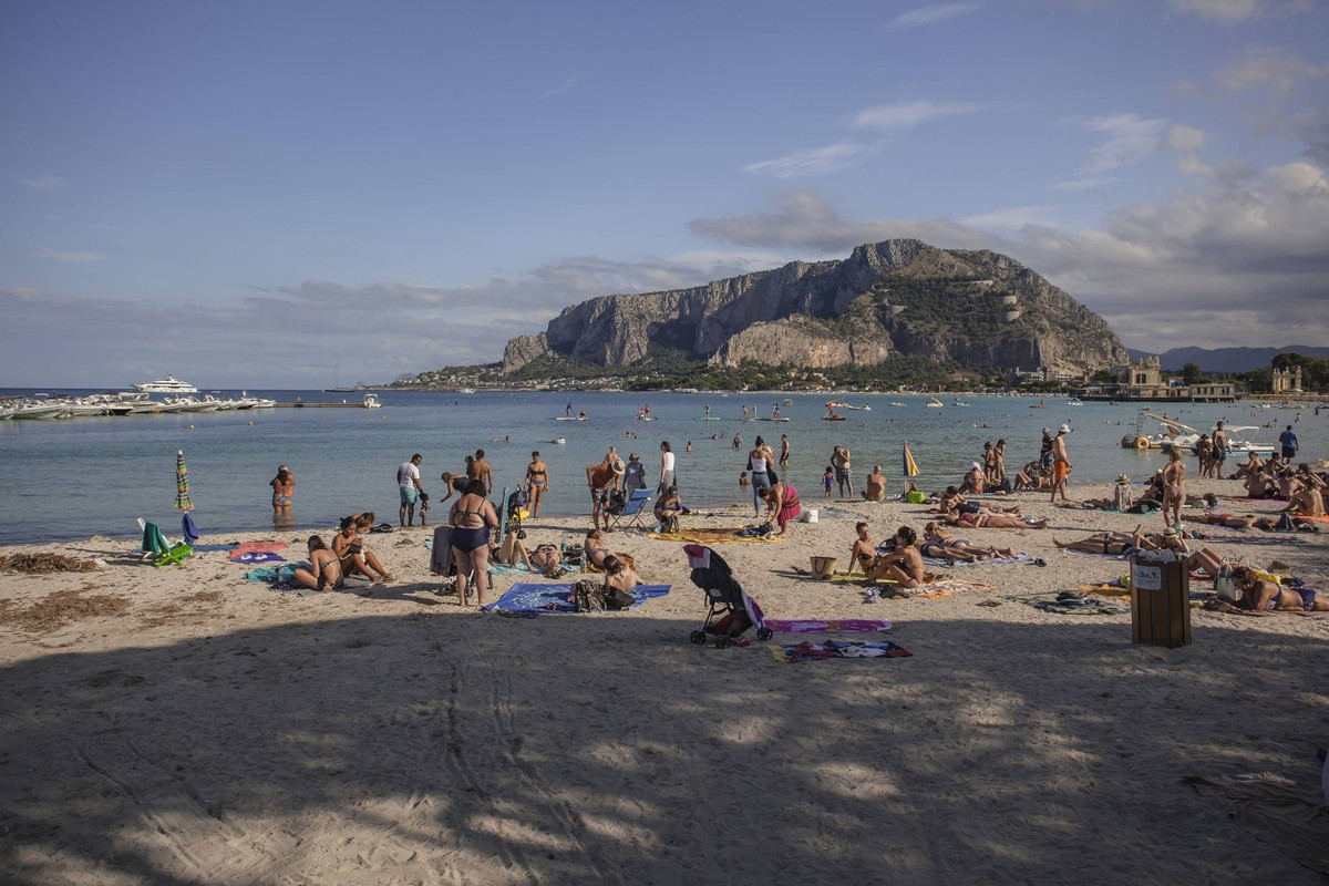 Tourists relaxing on the beach of mondello in sicily, italy Mondello, Italy 1 January 2025: Tourists enjoying summer holidays on the beach at mondello, a famous seaside resort in palermo, sicily, ital ...