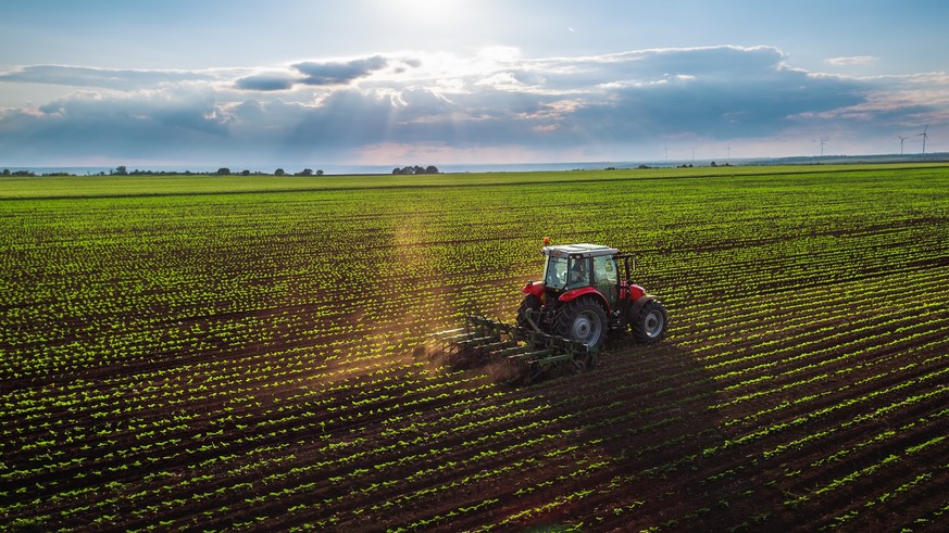 Tractor cultivating field at spring,aerial view