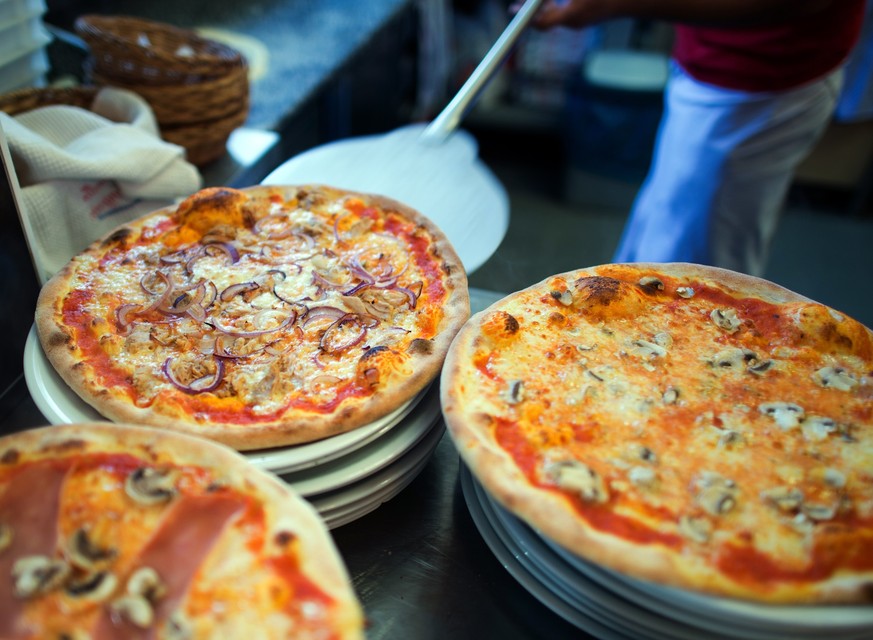 ILLUSTRATION - 10.02.2014, Berlin: ARCHIV - In einer Pizzeria liegen fertige Pizzen auf Tellern. Pizza und Pasta statt Schnitzel und Wurst: Der Geschmack wird immer internationaler. (zu dpa: D
