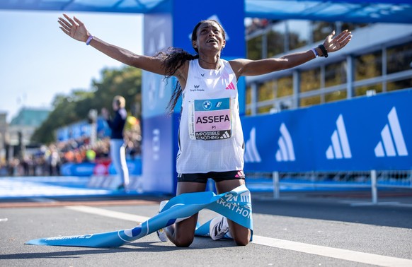 dpatopbilder - 24.09.2023, Berlin: Leichtathletik: Berliner Marathon. Tigst Assefa aus Äthiopien kniet am Boden nach ihrem Erfolg beim BMW Berlin Marathon. Nach 2:11:53 Stunden läuft sie als erste Fra ...