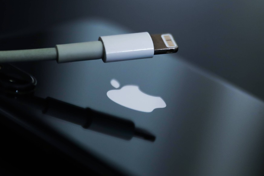 European Union Proposes Universal Plugs For Devices Lightning cable and Apple logo on iPhone are seen in this illustration photo taken in Krakow, Poland on September 25, 2021. Krakow Poland porzycki-e ...