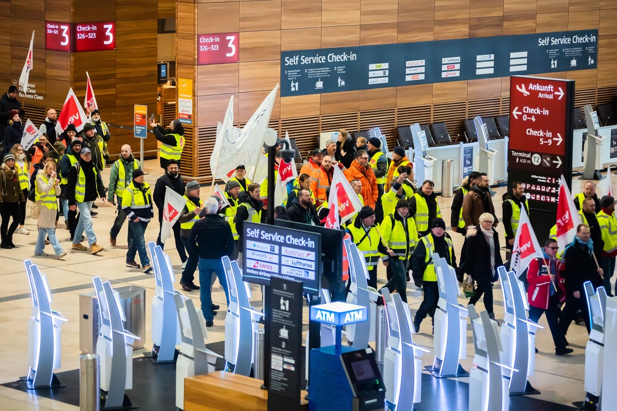 25.01.2023, Brandenburg, Schönefeld: Teilnehmer einer Demonstration zum Warnstreik am Flughafen Berlin-Brandenburg BER laufen durch das Terminal 1. Die Gewerkschaft Verdi hat zu einem ganztägigen Warn ...