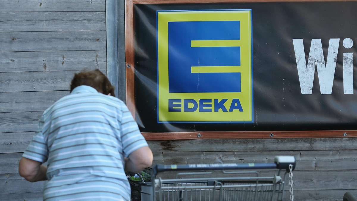 BERLIN, GERMANY - MAY 10: An elderly woman loads her purchases into a bicycle basket outside an Edeka supermarket on May 10, 2016 in Berlin, Germany. German anti-cartel authorities announced yesterday ...