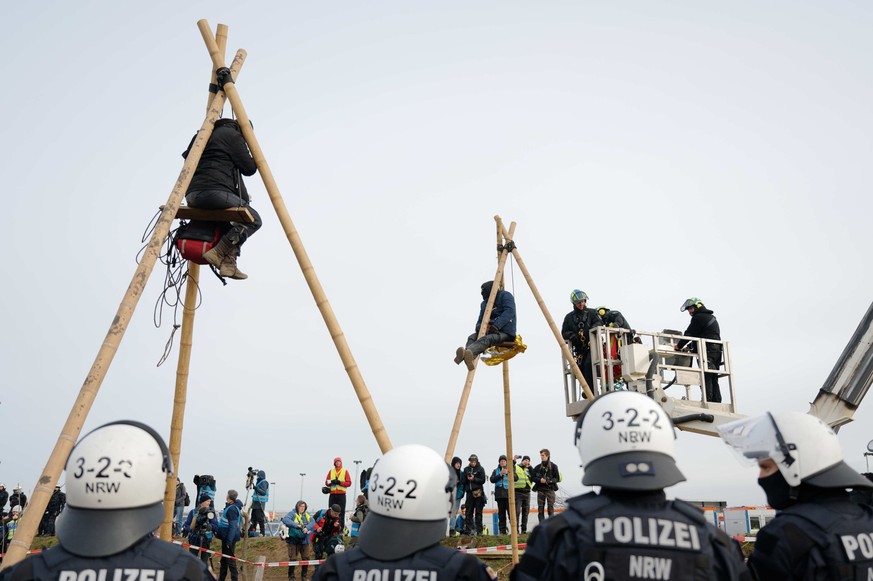 10.01.2023, Nordrhein-Westfalen, Erkelenz: Polizisten beginnen am Rand von Lützerath mit der Entfernung von sogenannten Tripods der Klimaschutzaktivisten. Lützerath soll zur Erweiterung des Braunkohle ...