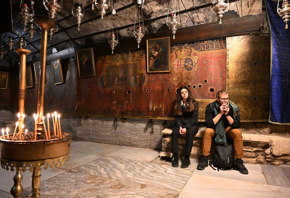 People visit the grotto in the Church of Nativity, believed to be the site of Jesus birth, in the biblical town of Bethlehem, West Bank, on Sunday, December 17, 2023. The church, normally packed with  ...