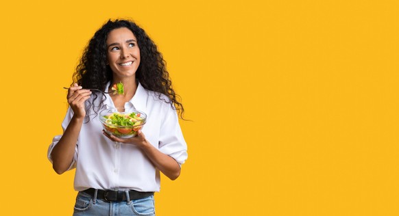 Frau mit Lunch vor gelbem Hintergrund