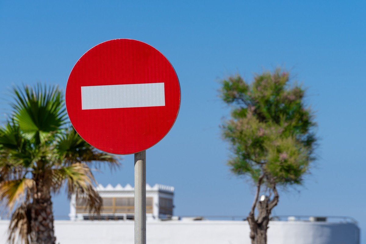 Spain, Mallorca, Palma, April 30, 2025 - Traffic sign no entry against palm trees and sky