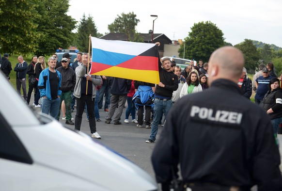 Vor dem Asylbewerberheim in Freital bei Dresden ist es am Mittwochabend (24.06.15)erneut zu Protesten gekommen (Foto: Asylkritiker halten eine deutsch-russische Fahne hoch). Den dritten Tag in Folge d ...