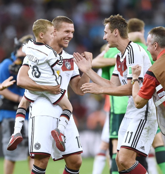 Weltmeister: Lukas PODOLSKI (Deutschland) mit seinem Sohn Louis auf dem Arm zusammen mit Miroslav KLOSE (Deutschland).

Jubel (Bejubelt, jubeln, Freude, Emotion, bejubeln, jubelt, freuen) nach dem Gew ...