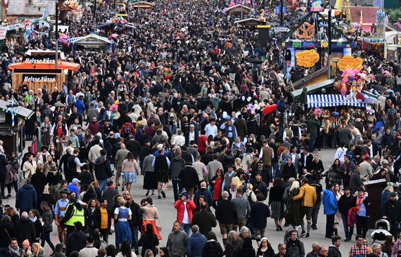 ARCHIV - 30.09.2022, Bayern, München: Besucher gehen beim Oktoberfest über die Theresienwiese. Erreger haben hier leichtes Spiel - nicht erst seit Corona. (zu dpa- Wiesn-Grippe, Wiesn-Corona - Impfung ...