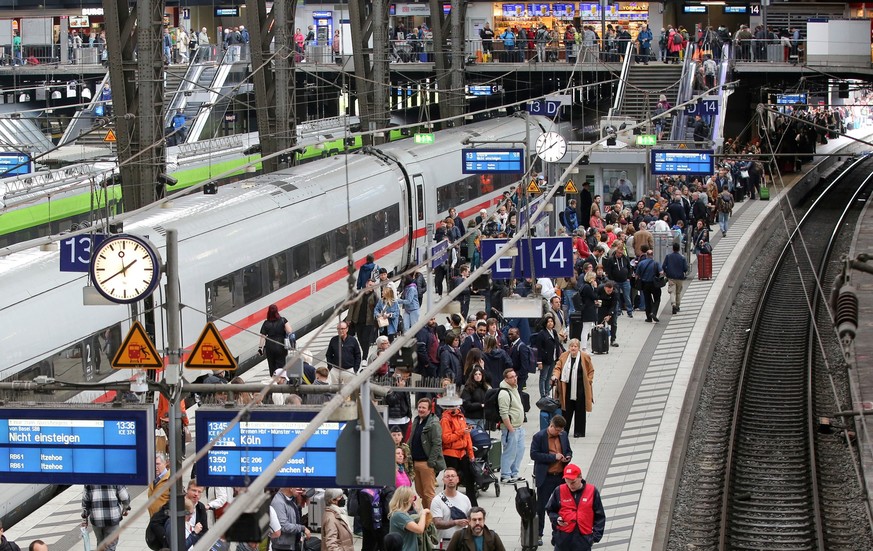 11.05.2023, Hamburg: Reisende warten im Hauptbahnhof in Hamburg auf ihren Zug. Die Deutsche Bahn rechnet angesichts des angek
