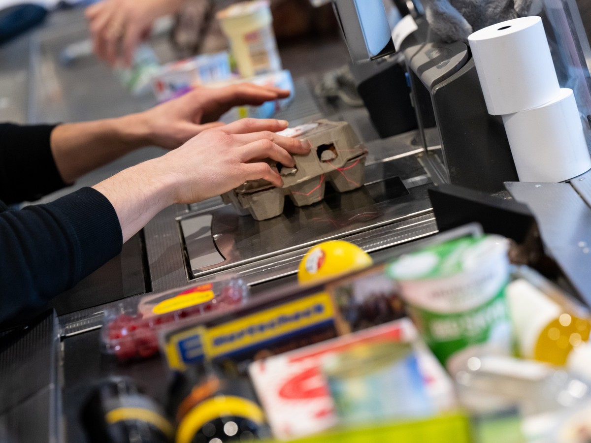 ARCHIV - 18.01.2023, Bayern, Neubiberg: Ein Kassierer scannt in einem Supermarkt an der Kasse die Produkte. Wie sich die Inflation in Deutschland im M