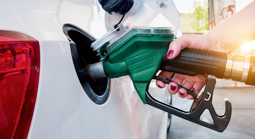 Woman refueling a car at a gas Station with sunlight in the background. ideal for websites and magazines layouts