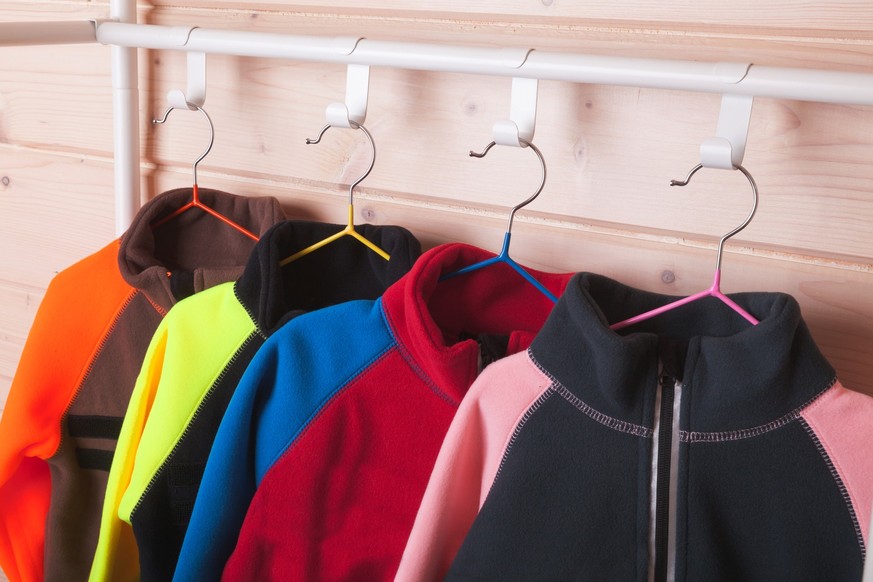 Colorful fleece jackets are on a rack
