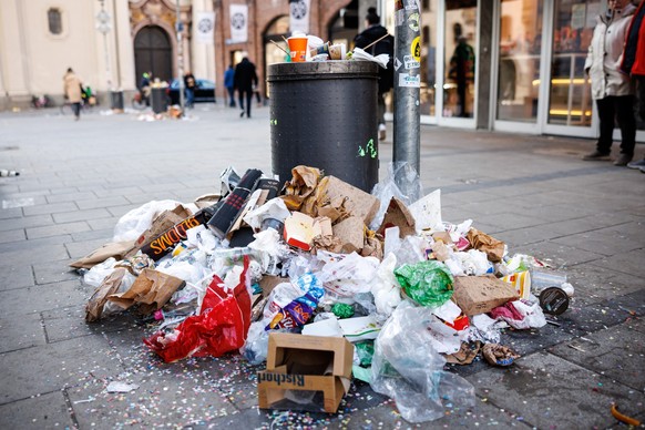 22.02.2023, Bayern, München: Ein überfüllter Mülleimer ist während eines zweitägigen Warnstreiks der Münchner Straßenreiniger am Marienplatz zu sehen. Wegen des Streiks der Münchner Straßenreiniger is ...