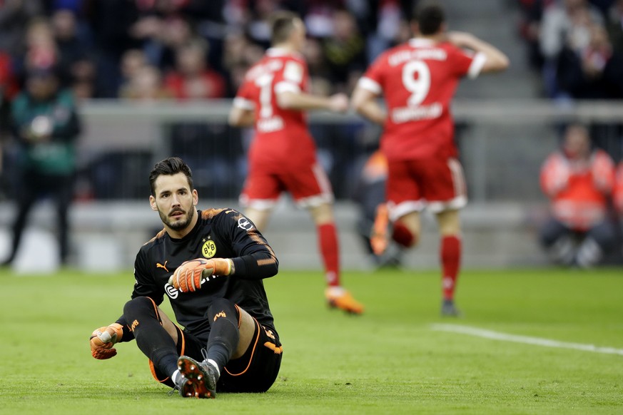 Dortmund goalkeeper Roman Buerki sits on the ground after Bayern&#039;s Robert Lewandowski scored his side&#039;s opening goal during the German Bundesliga soccer match between FC Bayern Munich and Bo ...