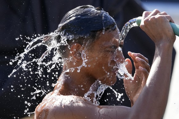 A man douses himself with water along a street as hot temperatures continue in Manila, Philippines on Friday, April 26, 2024. Parts of the country continue to experience extremely hot weather due to t ...