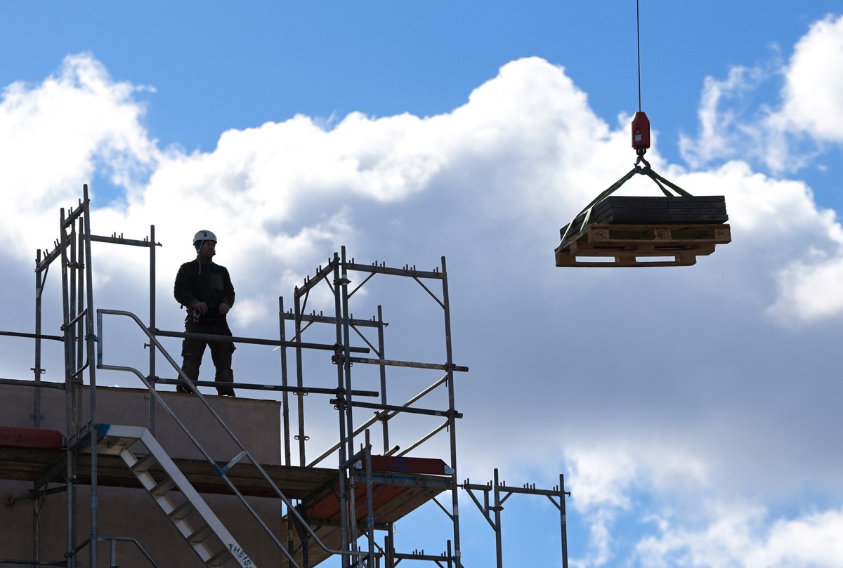 ARCHIV - 05.03.2021, Brandenburg, Potsdam: Ein Arbeiter dirigiert auf einer Baustelle einen Kran. Im Handwerk hat sich die konjunkturelle Lage insgesamt verbessert. Nach dem aktuellen ZDH-Konjunkturbe ...