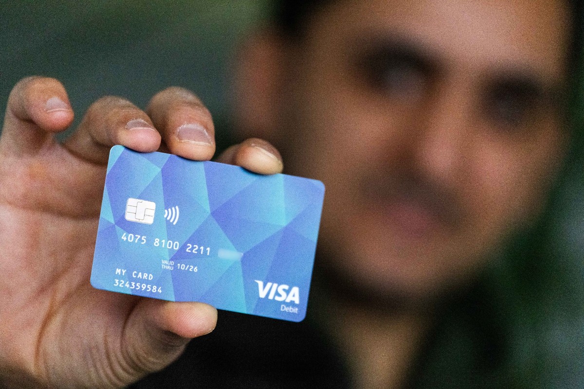 PRODUKTION - 17.01.2024, Baden-Württemberg, Offenburg: Ein Geflüchteter hält eine Debitcard in der Hand. Der Ortenaukreis zwischen Rhein und Schwarzwald will von diesem Dienstag an die ersten Bezahlka ...