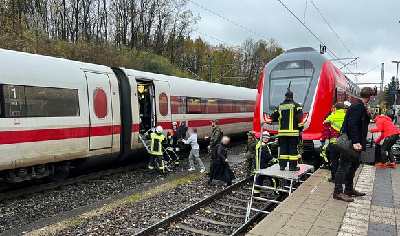 17.11.2023, Bayern, Reichertshausen: Rettungskräfte helfen den Passagieren beim Verlassen des ICE (l) an der Unfallstelle. Bei einem Zugunfall auf der Strecke zwischen München und Ingolstadt sind am F ...