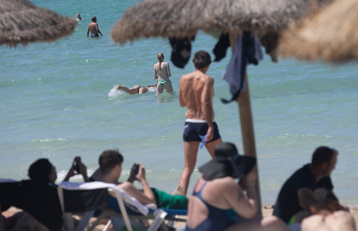 30.05.2025, Spanien, Palma: Menschen schwimmen und sonnen sich am Strand von Arenal auf Mallorca. Von Ende Mai bis zum kommenden Montag herrscht in Spanien eine frühlingshafte Hitzewelle mit Temperatu ...