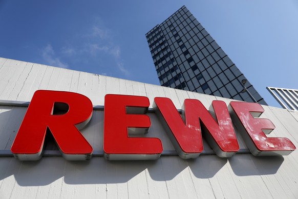 ARCHIV - 15.04.2021, Nordrhein-Westfalen, K�ln: Ein Rewe Schriftzug h�ngt vor einem Supermarkt. Auch der�Handelsriese Rewe hat 2022 in seinen Superm�rkten die negativen Auswirkungen der enorm gestiege ...