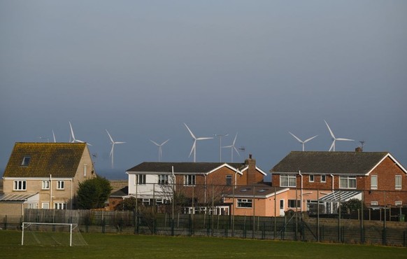 Wind turbines at RWE&#039;s Scroby Sands Wind Farm, are pictured on th horizon beyond residential houses, in Great Yarmouth, eastern England, on February 15, 2023. (Photo by Daniel LEAL / AFP) (Photo  ...