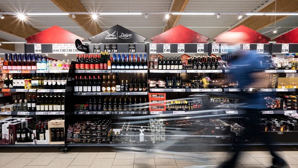 ARCHIV - 15.12.2021, Nordrhein-Westfalen, Kaarst: Ein Mann geht mit seinem Einkaufswagen in einer Lidl-Filiale an Regalen mit Sansibar und Deluxe-Produkten vorbei. In Nordrhein-Westfalen hat sich die ...