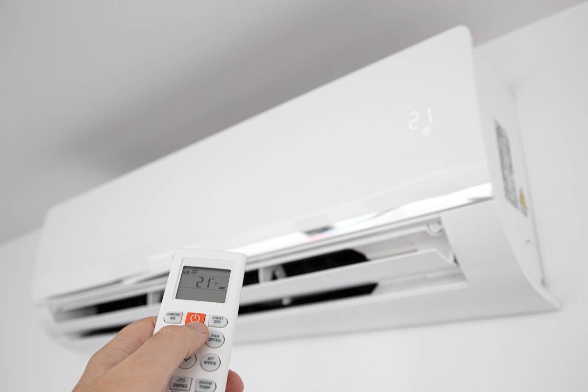 Hand operating a Remote control of a Domestic Air conditioner unit mounted on wall Hand operating a Remote control of a Domestic Air conditioner unit mounted on wall Copyright: xZoonar.com/AndresxVict ...