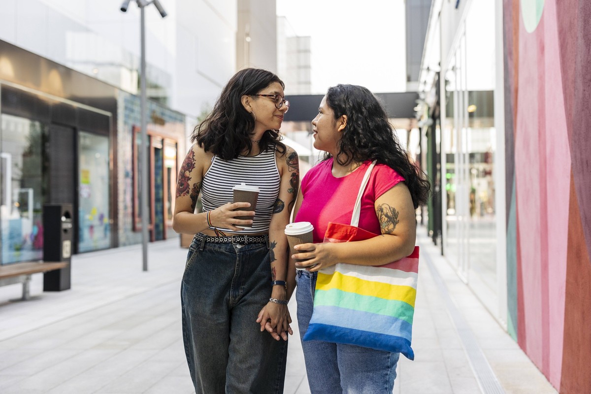 Young gay couple holding hands and walking at street model released, Symbolfoto property released, JCCMF12476